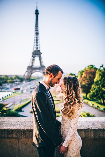 Photo of young married couple in front of an Eiffel tower.