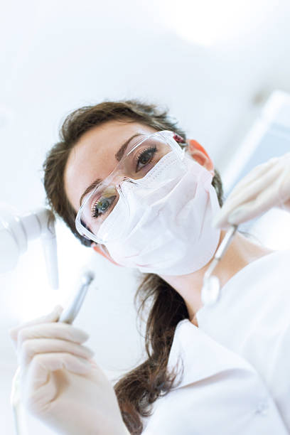 istock Dentist in mask holding angled mirror and drill 476994140
