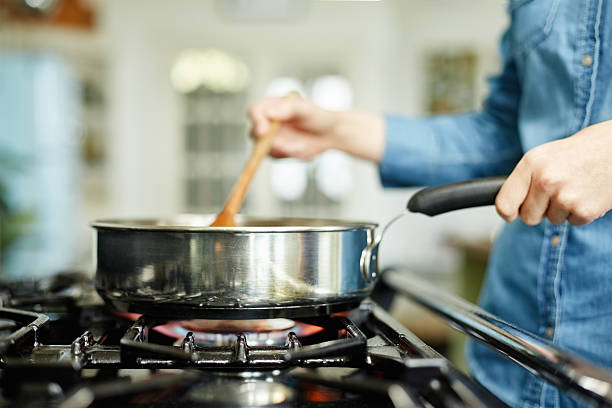gros plan de femme cuisine dans cuisine poêle - stove top photos et images de collection