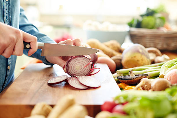 Midsection image of woman cutting onion in kitchen