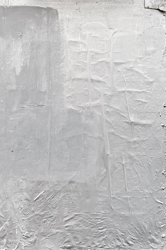 Textured white urban wall background with tape and paper painted over with white paint.