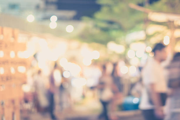 istock Abstract blurred people in night market for background 477001030