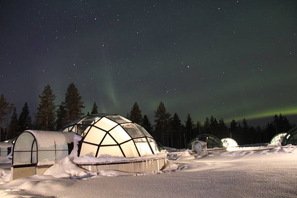 northern lights over glass igloos en finlandia - iglú fotografías e imágenes de stock