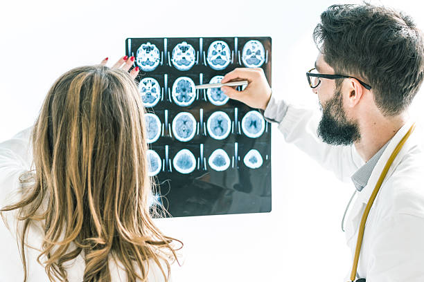 coppia di medici esaminando il ai raggi x del cervello - doctor brain x ray x ray image foto e immagini stock