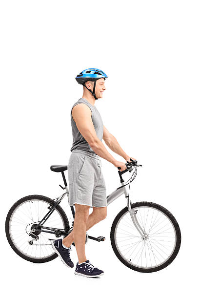 istock Active young man pushing a bike and smiling 477004136