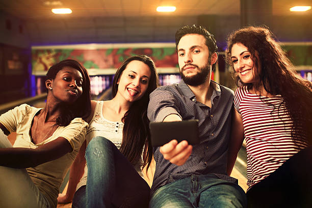 istock Four friends having fun and taking selfie at the bowling 477004278