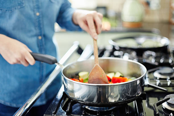 istock Midsection of woman cooking vegetables in pan 477004524