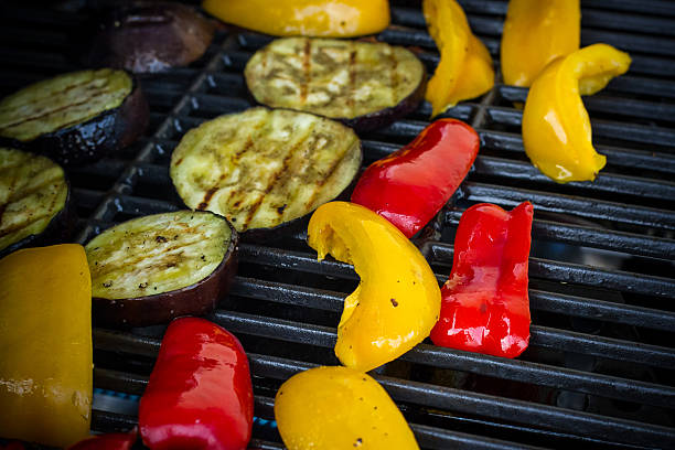 istock Red and yellow peppers, eggplant slices on grill rack 477005948
