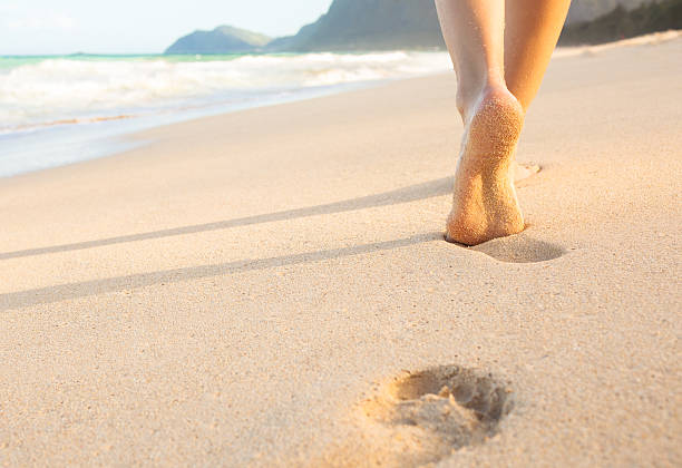Beach travel Closeup detail of female feet and golden sand on beach in Hawaii. walking beach women sadness stock pictures, royalty-free photos & images