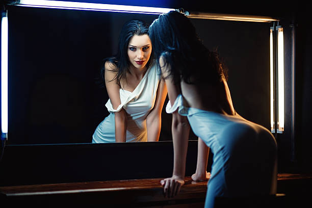 portrait of beautiful young woman looking into the mirror - förförisk kvinna bildbanksfoton och bilder