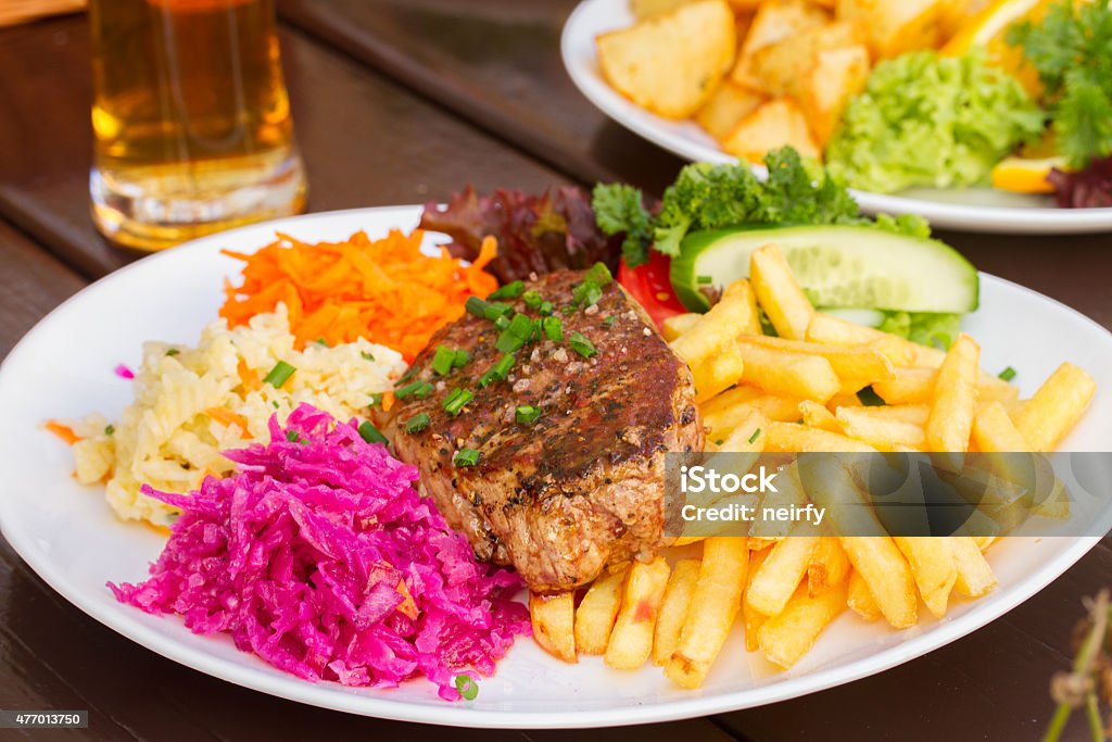 plate of meat steak with garnish plate of  meat steak , french fries and red pricled  cabbage 2015 Stock Photo