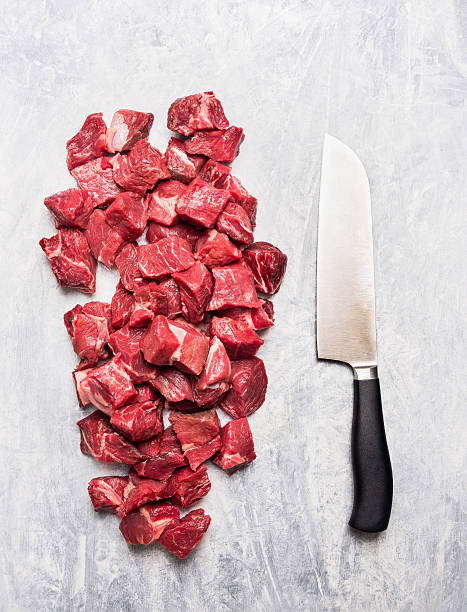 Raw beef goulash meat diced for stew with  knife
