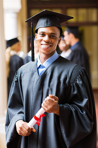 hombre afro americano de posgrado - poses para fotos de graduación fotografías e imágenes de stock