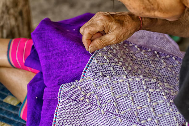 istock Woman hand stitching cloth to make ancient Thai pattern fabric 477016970