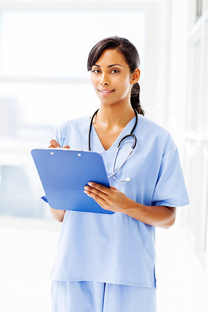 istock Confident Nurse Writing On Clipboard In Hospital 477022192