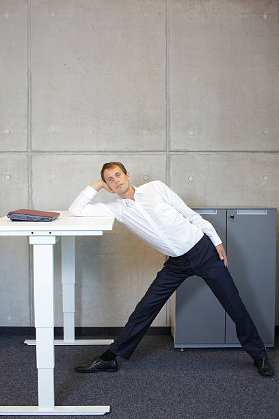 istock yoga in office. business man exercising at workplace 477024688
