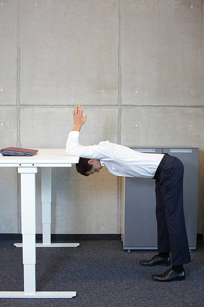 istock yoga in office. business man exercising at workplace 477024690