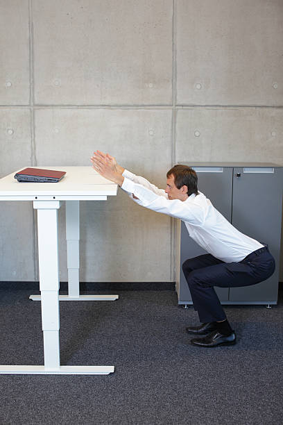 istock yoga in office. business man exercising at workplace 477024696