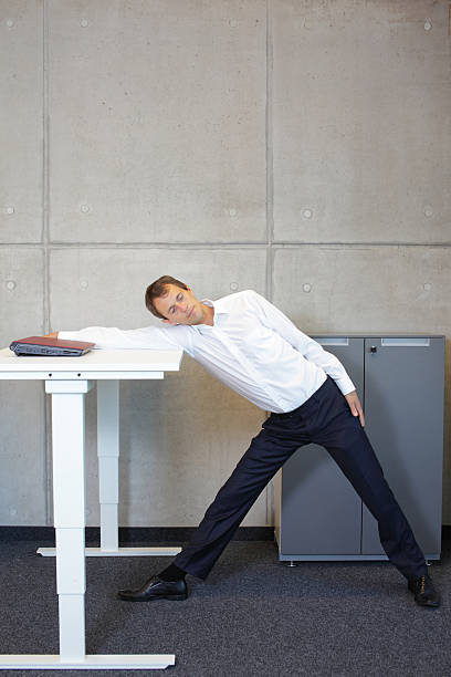 istock yoga in office. business man exercising at workplace 477024698