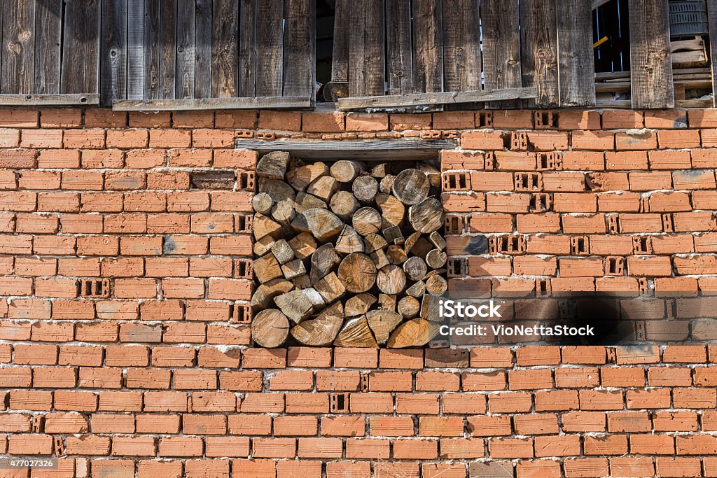 Brick wall with woods Wooden material stored in brick wall 2015 Stock Photo