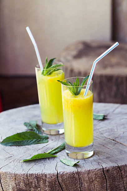 istock Orange drink on wooden table, selective focus 477028086