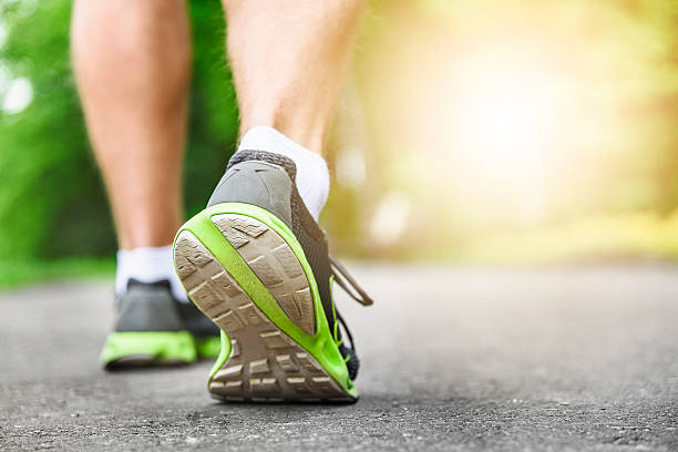 istock Athlete runner feet running on road 477033356