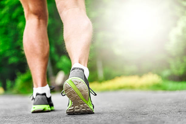 istock Athlete runner feet running on road 477033364