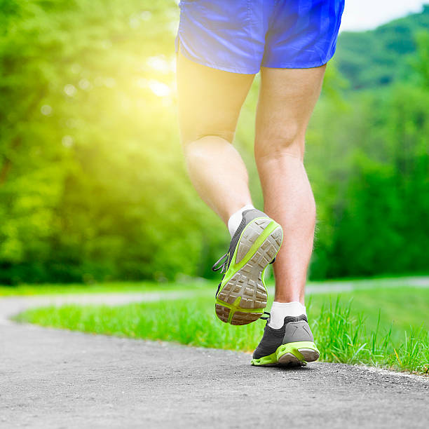 istock Athlete runner feet running on road 477033374