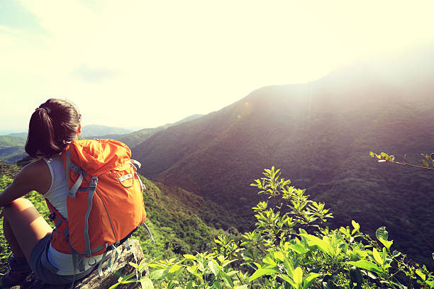 istock woman backpacker enjoy the view at mountain peak cliff 477033380