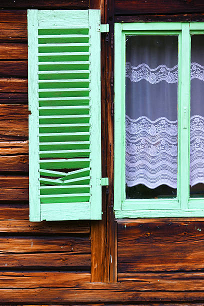 istock Green wooden window shutters on old house 477034164