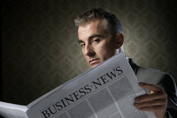 istock Businessman holding newspaper 477036249