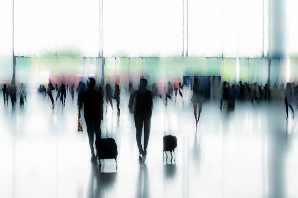 istock Motion Blurred Travellers Rushing at Airport Pulling Luggage 477042020