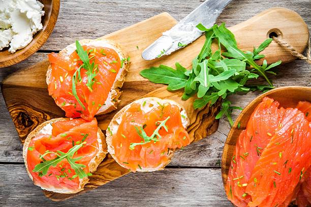 сэндвичи и копченый лосось с рукколой, сыр, - appetizer salmon smoked salmon cracker стоковые фото и изображения