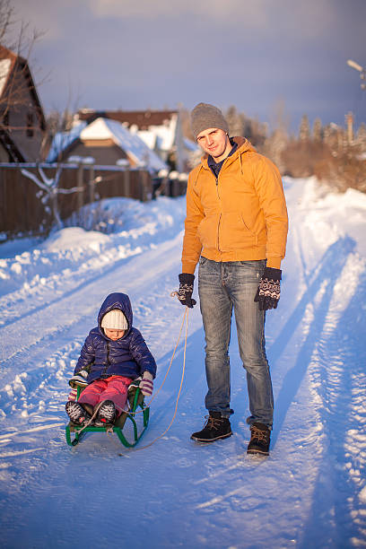 istock Young dad sledding his little daughter on winter day 477050837