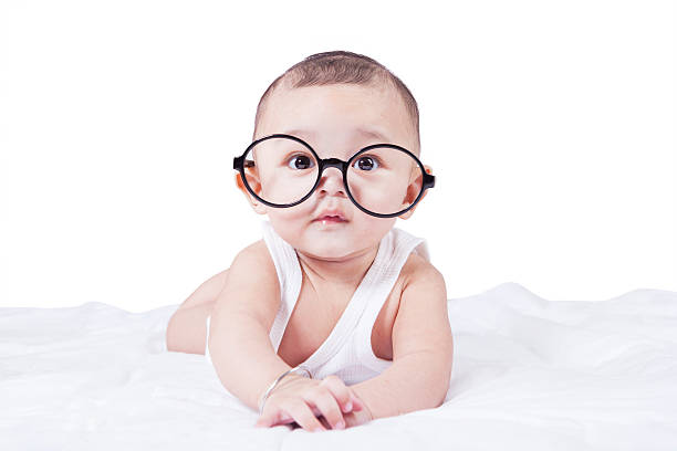 istock Baby boy with glasses lying on bed 477053860