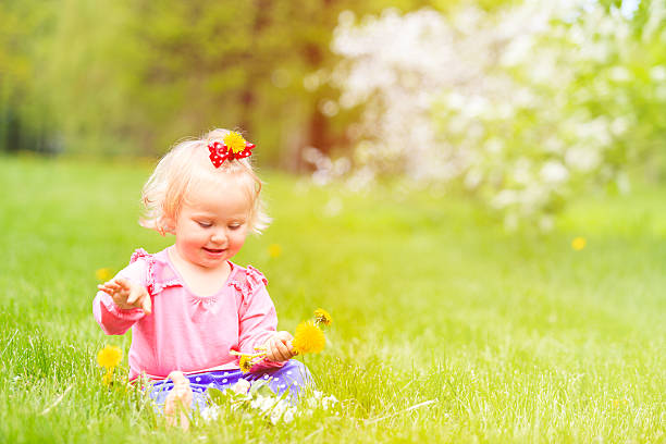 istock cute little girl with flowers in spring nature 477061276
