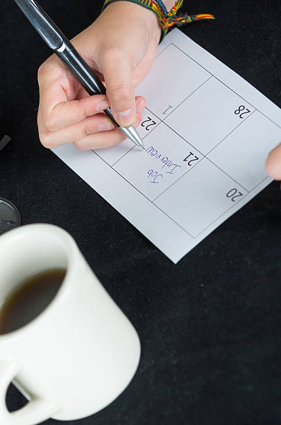 istock hand writing on paper calendar next to coffee mug 477061524