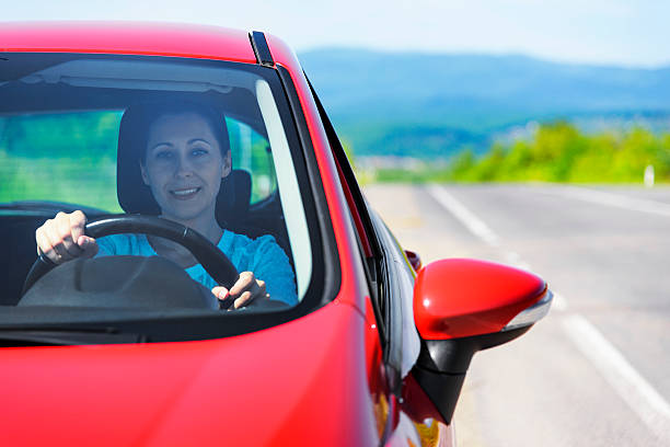 istock Woman in red car 477062594