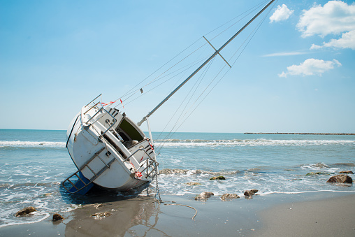 sailboat wrecked and stranded on beach