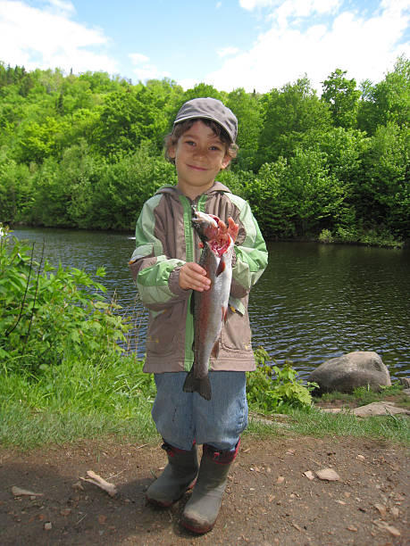 istock boy showing the trout he caught 477067357