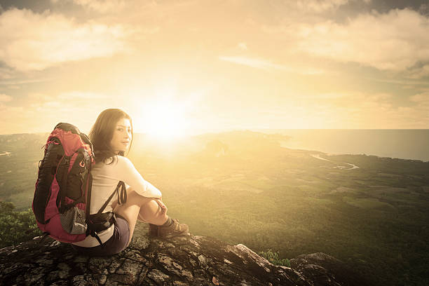 istock Woman with backpack sitting on mountain 477074056