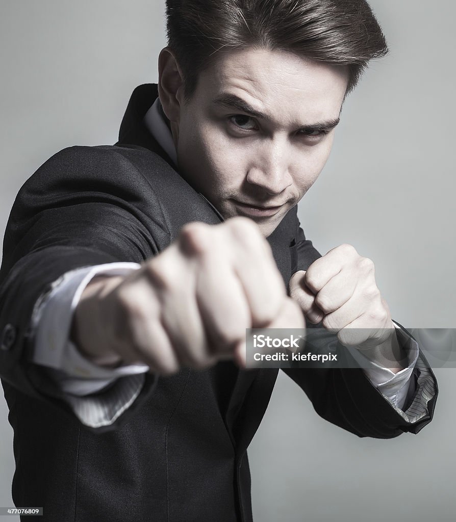 Business man throwing punch Handsome business man with fighter spirit. Activity Stock Photo