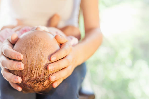 istock Mother holding baby head at hands 477076926