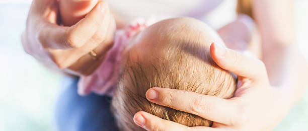 istock Mother holding baby head at hands 477087870