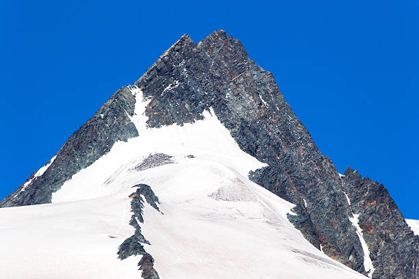 istock pinnacle with snow beneath and a clear blue sky above 477088049