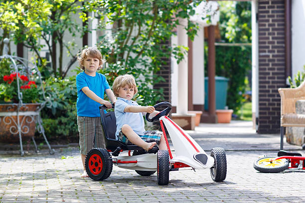 istock Two happy sibling boys having fun with toy car 477097018