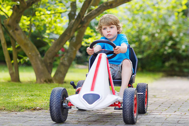 activa niño divirtiéndose y conducir coches de carrera de juguete - car child teamwork sports race fotografías e imágenes de stock