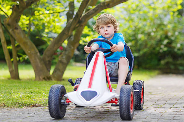 istock Active little boy having fun and driving toy race car 477097280