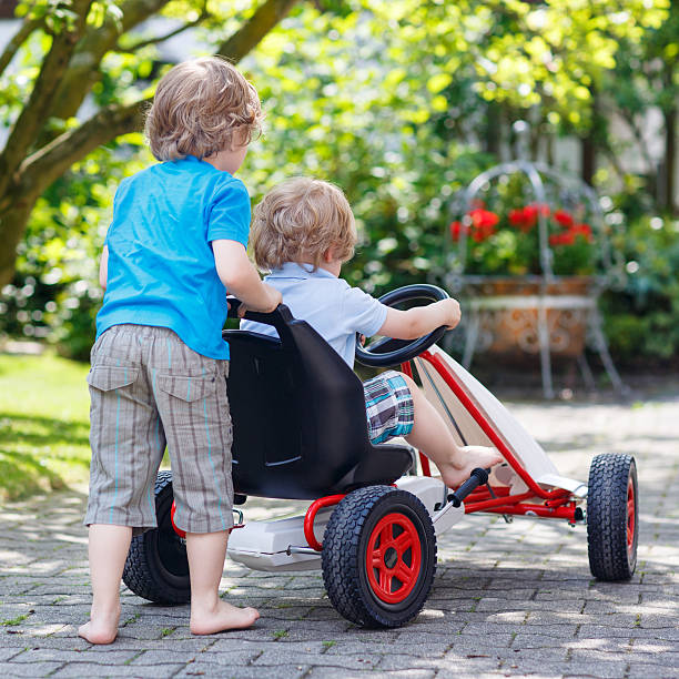 istock Two happy sibling boys having fun with toy car 477097362