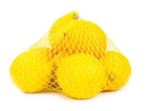 Photo of lemons in a yellow bag isolated on white